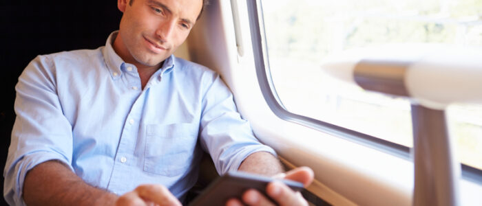 A man on a train reading from an ebook reader