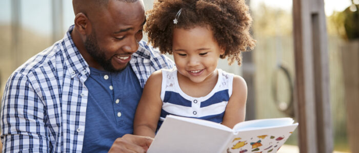 Dad reading a book to his daughter